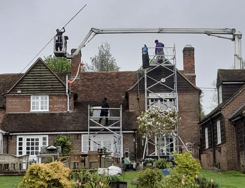 The Roof Moss Cleaners using cherry picker and scaffolding to clean roof safely and professionally in Hook, Hampshire